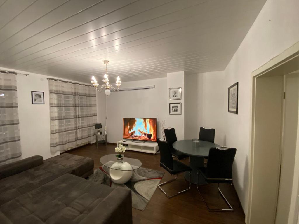 a living room with a couch and a table and a tv at L1 Apartments in Neunkirchen