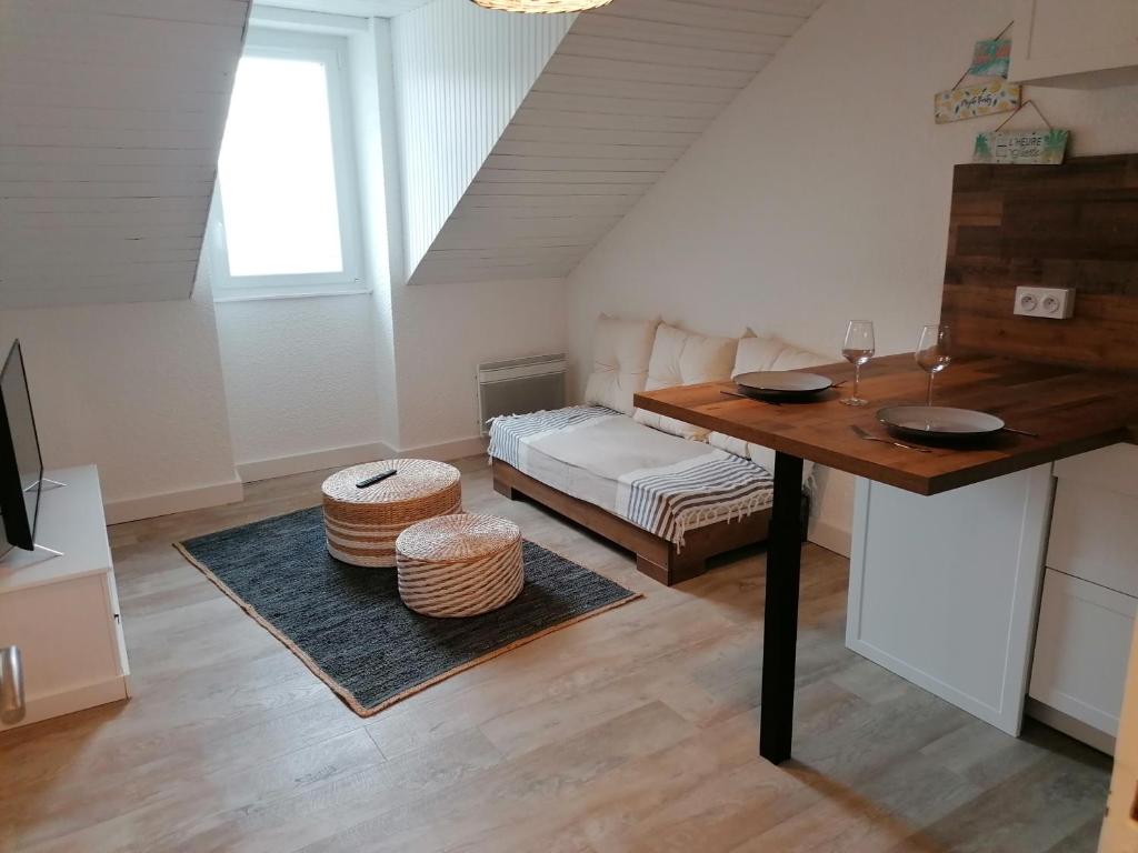 a living room with a table and a bed at Esprit Mer classé - Wifi - Centre in Auray
