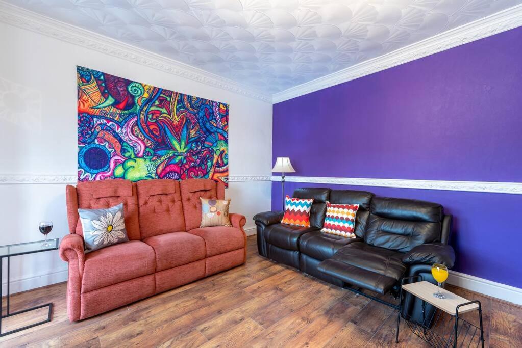 a living room with a couch and a colorful wall at The Miracle Spacious 2 Bedroom 3 Beds Central Hull in Hull