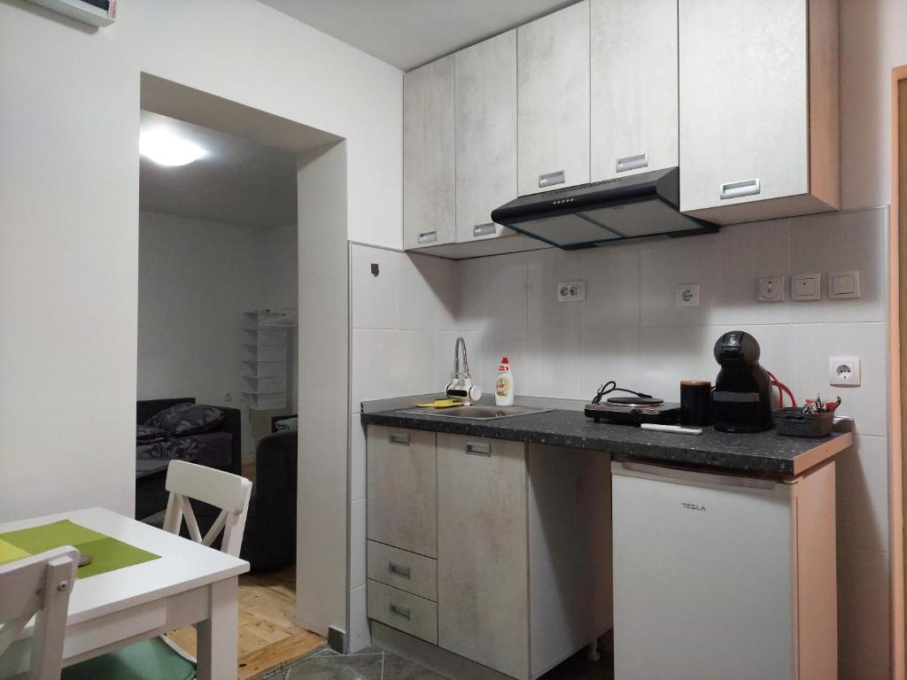 a kitchen with white cabinets and a counter top at Apartman Centar in Kragujevac