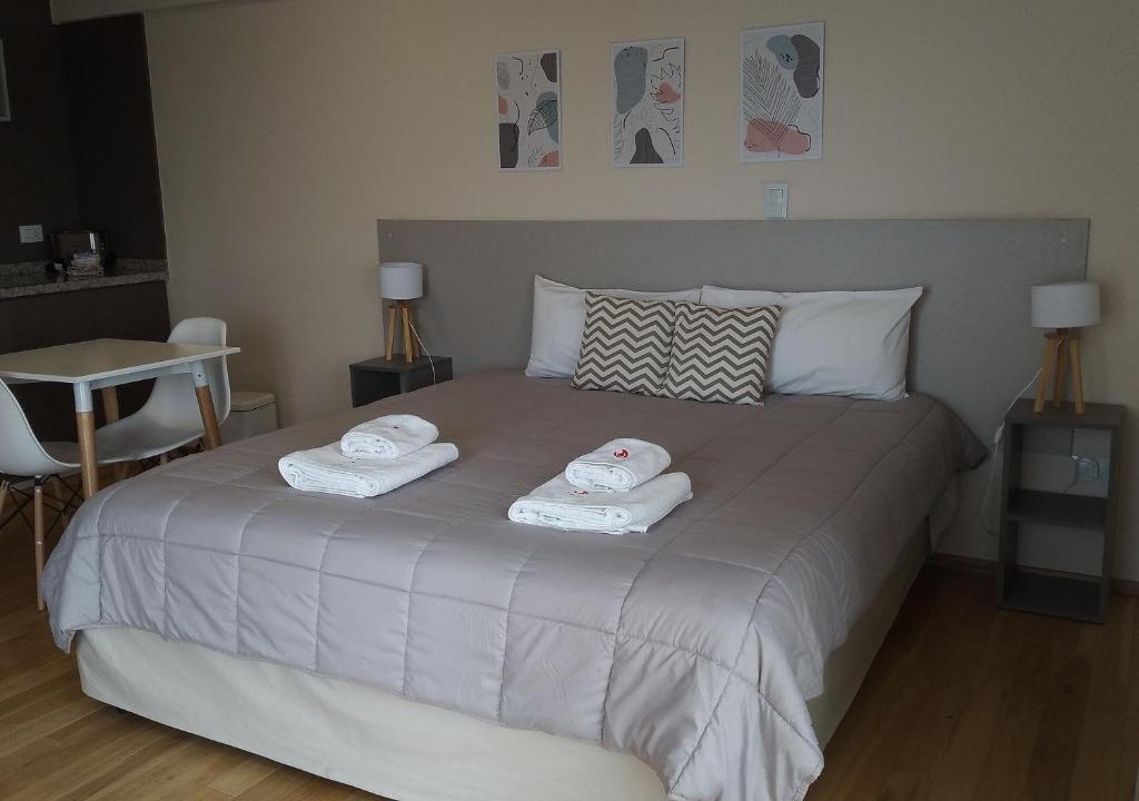 a bedroom with a bed with two towels on it at Apart Hotel Quijote by DOT Suites in Ciudad Lujan de Cuyo