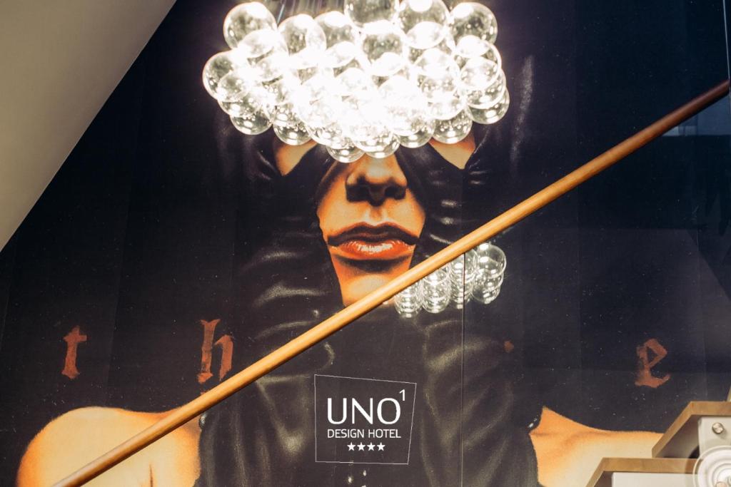 un póster de un hombre con una lámpara de araña en UNO Design Hotel en Odesa