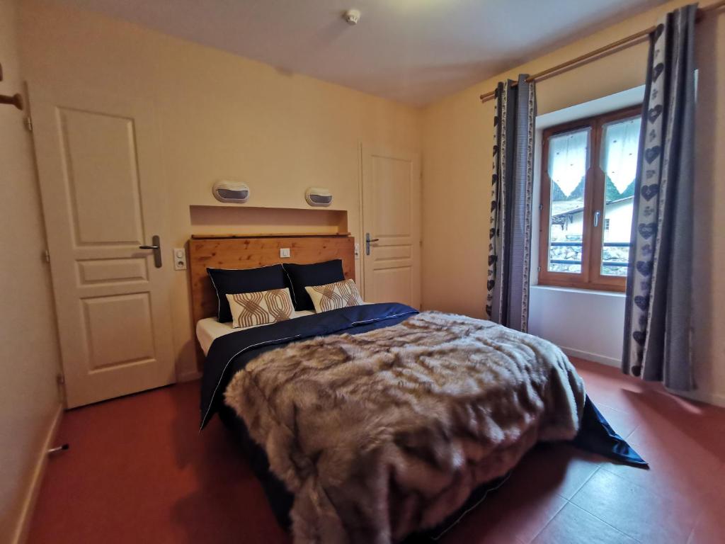 a bedroom with a large bed and a window at Auberge du Freney in Le Freney-dʼOisans