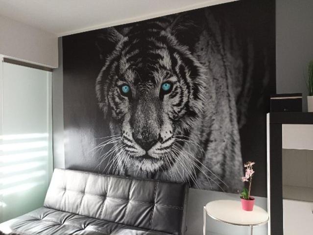 a painting of a tiger with blue eyes on a wall at Apartament Tygrys in Zakopane