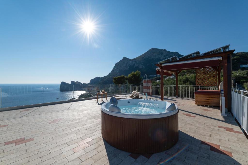 a hot tub on a patio with a view of the ocean at MAIN Roof Terrace Apartment in Nerano