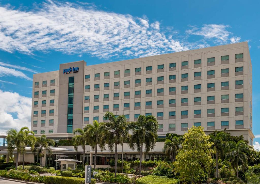 a hotel with palm trees in front of a building at Park Inn by Radisson Davao in Davao City