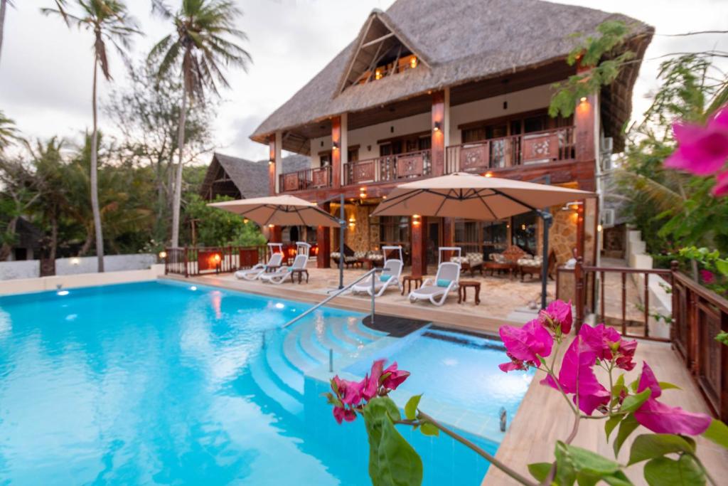 een villa met een zwembad en een huis bij Cast Away Residence in Kiwengwa