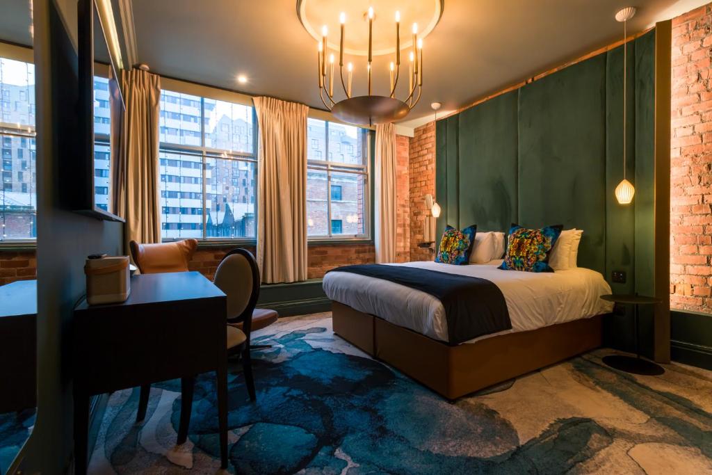 a bedroom with a large bed and a large window at Velvet Hotel in Manchester