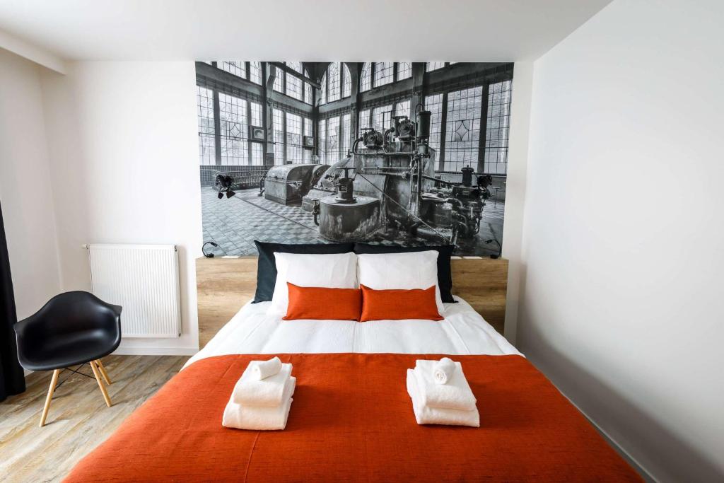 a bedroom with a large bed with two orange pillows at B-INN Lier in Lier