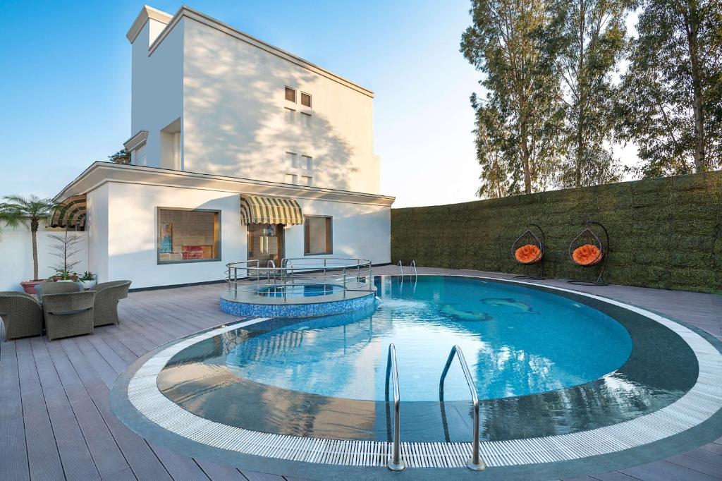 a swimming pool in the middle of a patio at Country Inn & Suites by Radisson Chandigarh Zirakpur in Chandīgarh