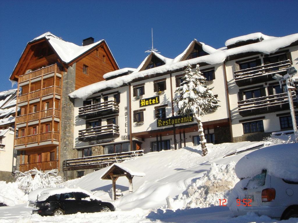 un edificio con nieve en el suelo delante de él en Hotel Tirol, en Formigal