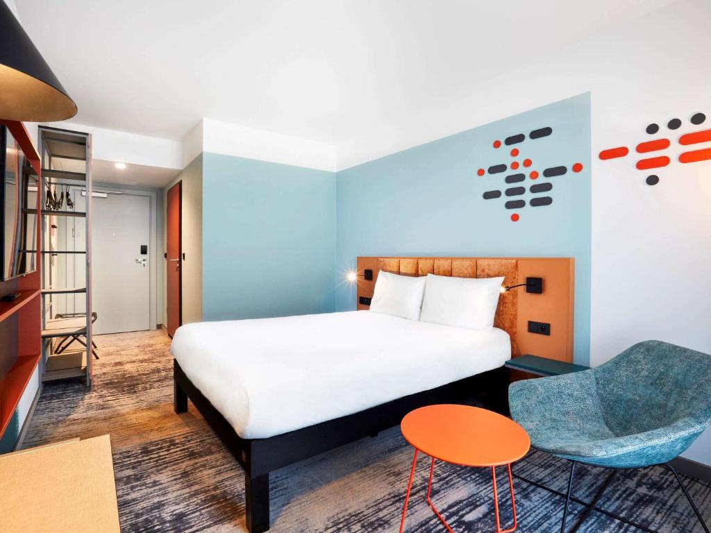 a hotel room with a bed and a chair at ibis Styles Kraków Centrum in Krakow