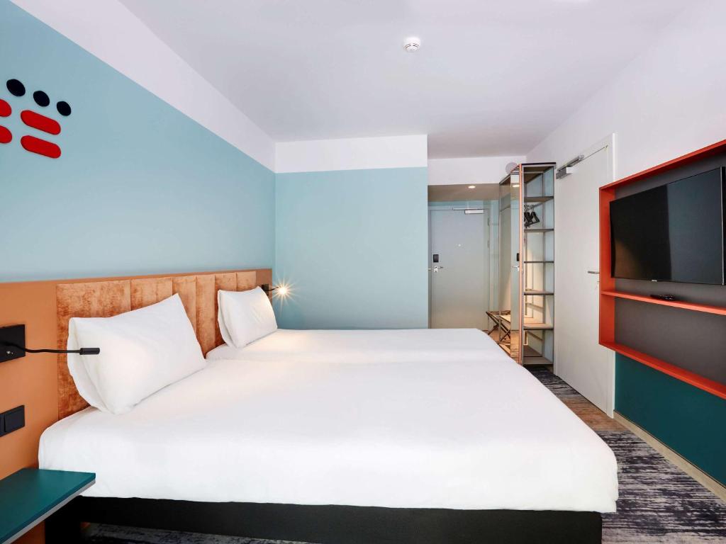 a bedroom with a bed and a flat screen tv at ibis Styles Kraków Centrum in Krakow