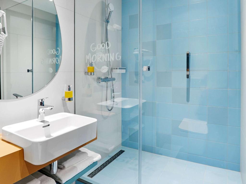 a bathroom with a sink and a glass shower at ibis Styles Kraków Centrum in Krakow