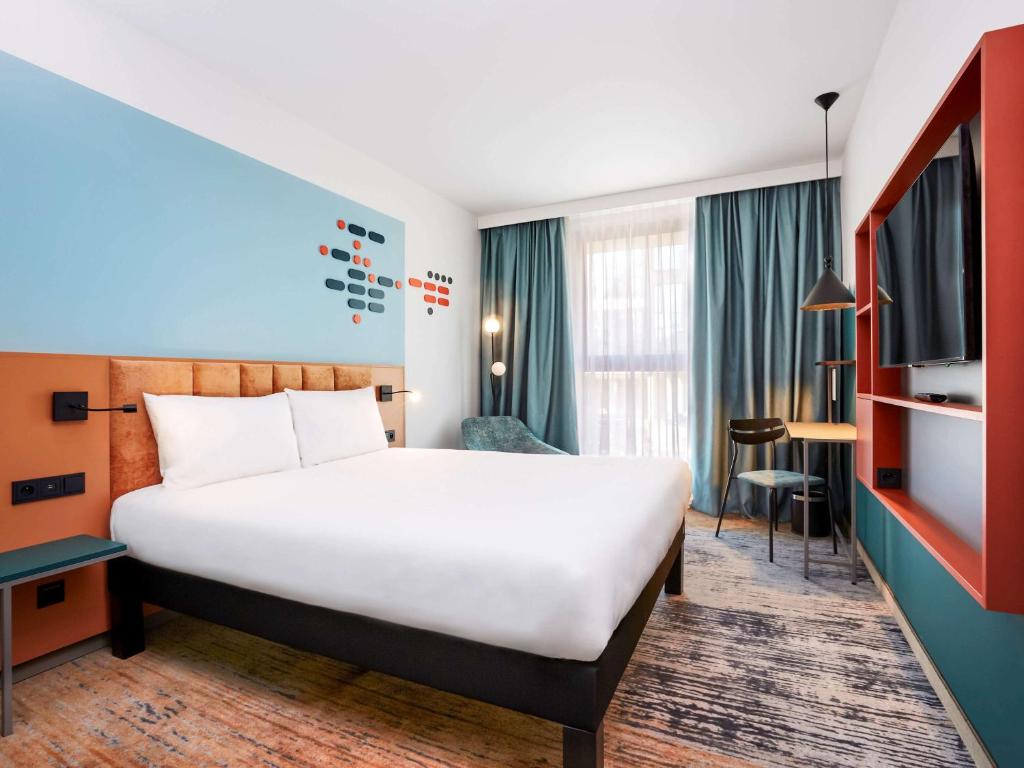 a hotel room with a bed and a desk at ibis Styles Kraków Centrum in Krakow