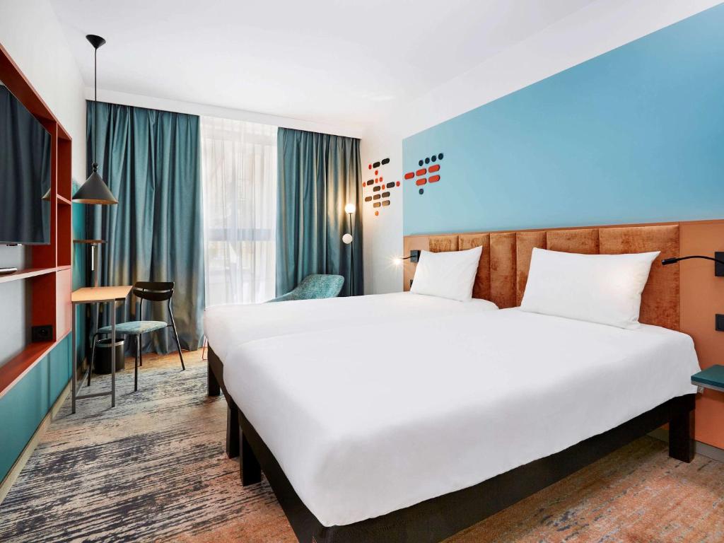 a hotel room with a large bed and a desk at ibis Styles Kraków Centrum in Krakow