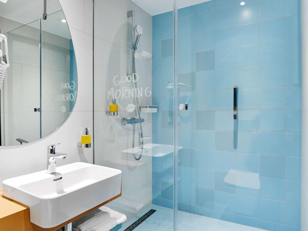 a bathroom with a sink and a glass shower at ibis Styles Kraków Centrum in Krakow