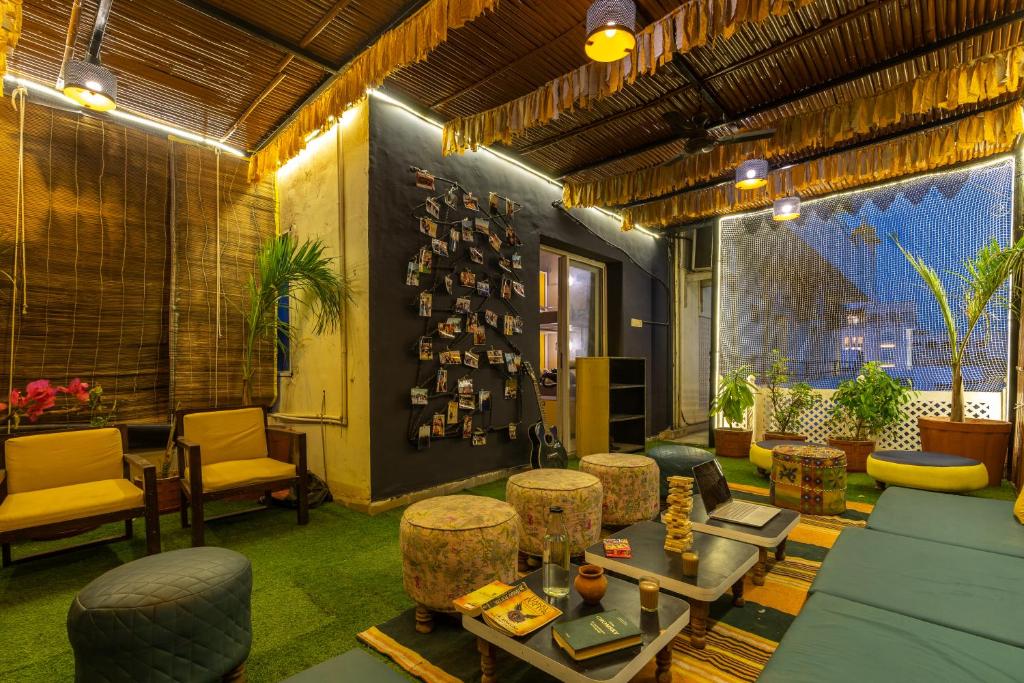a living room with couches and tables and chairs at The Hosteller Jaipur in Jaipur