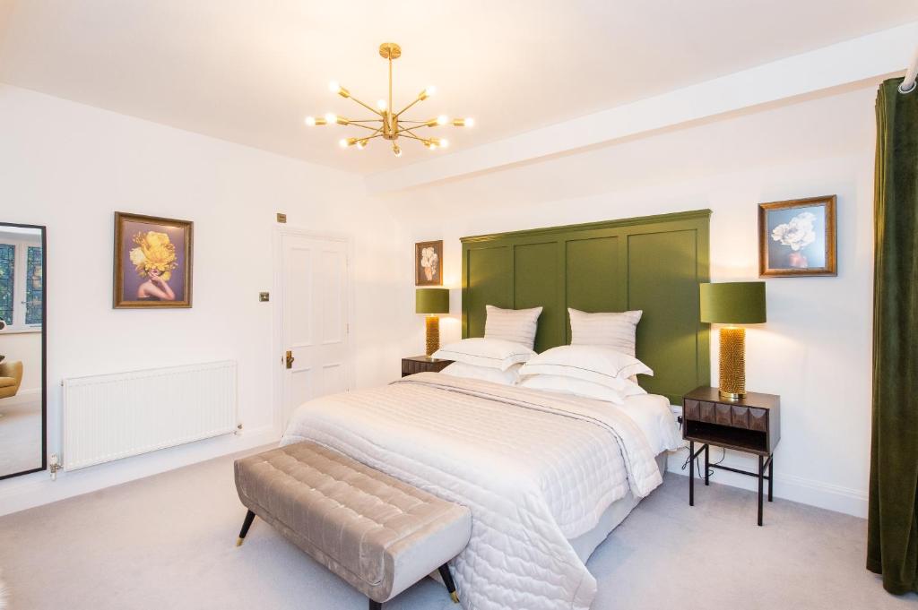 a bedroom with a large bed with a green headboard at The Tower by Harrogate Serviced Apartments in Harrogate