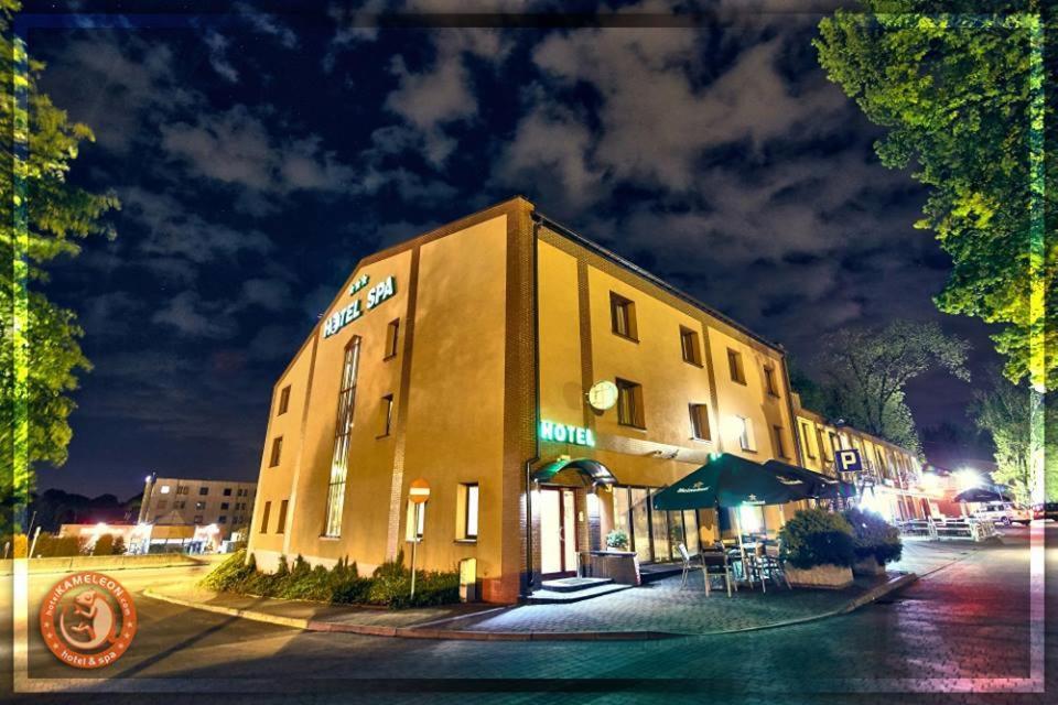 a building with a restaurant on a street at night at Hotel&Spa Kameleon in Żory