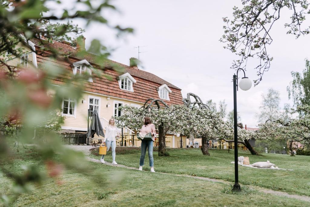 Due ragazze sono in piedi davanti a una casa di Tammiston Bed&Breakfast a Naantali