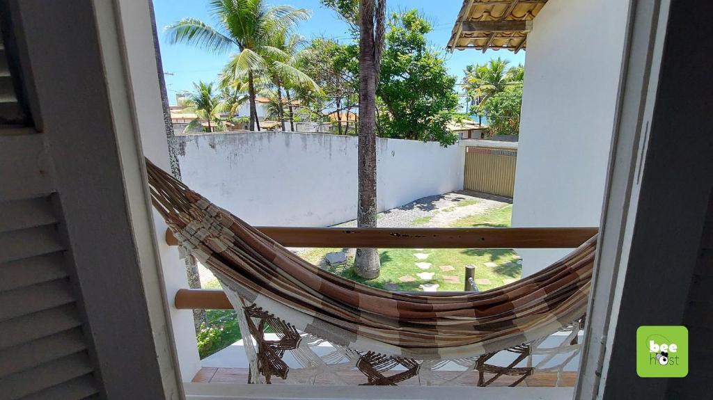 eine Hängematte auf dem Balkon eines Hauses in der Unterkunft ONJAU0102 - Village super confortável bem perto da praia de Jauá por Beehost in Cajiru