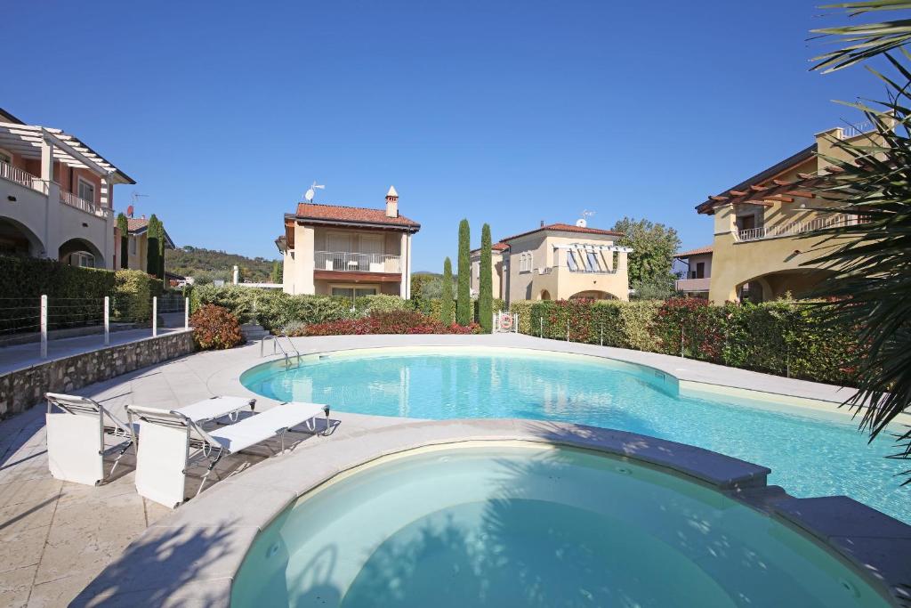 einen Pool mit Stühlen und ein Haus in der Unterkunft Casa della Romantica in Manerba del Garda