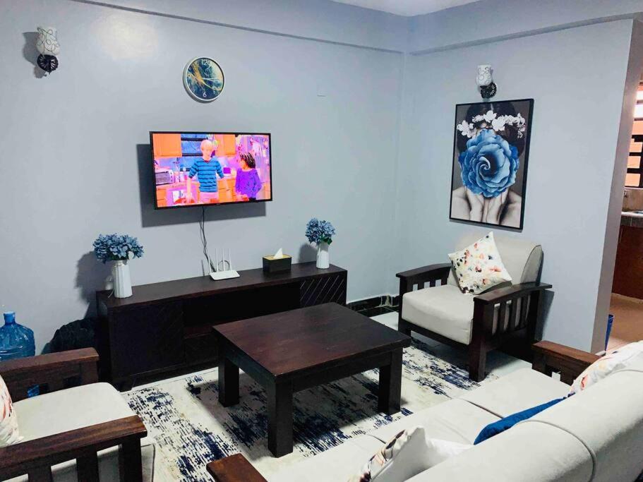 - un salon avec un canapé et une table dans l'établissement EM's Place Bridge View Furnished Apartments Naivasha, à Naivasha
