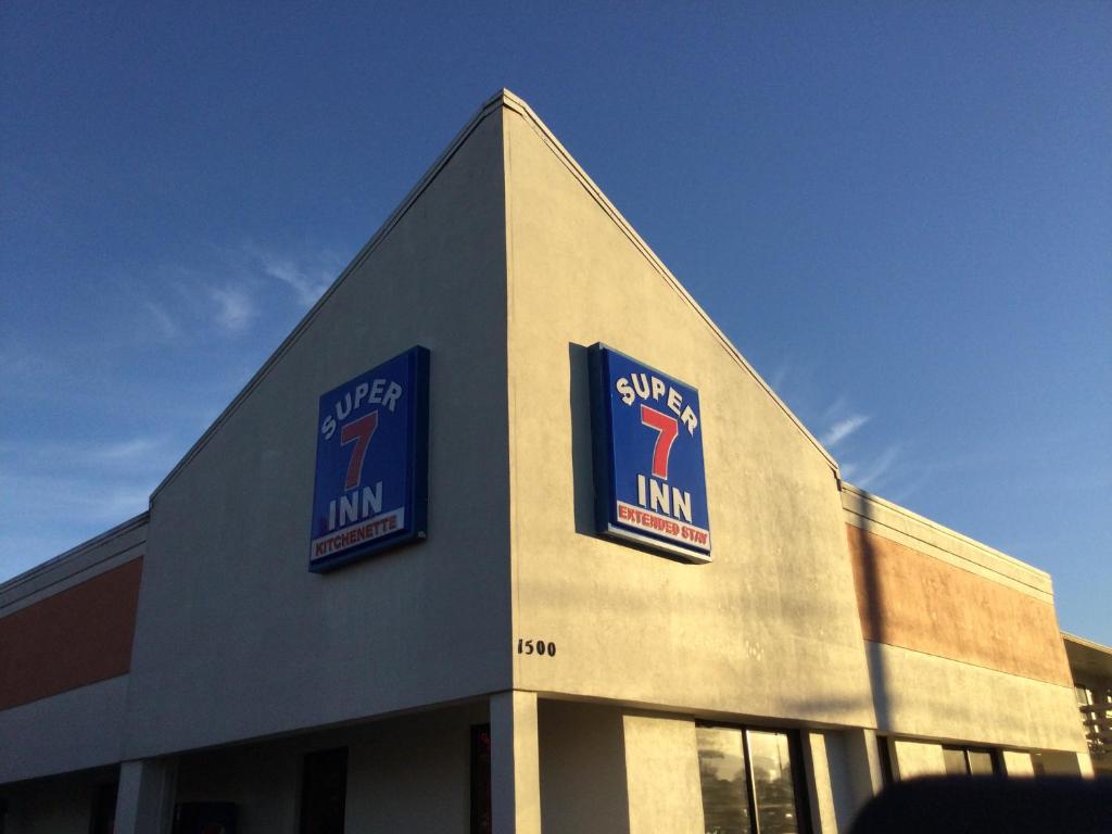 un edificio con dos letreros a un lado en Super 7 Inn en Tupelo