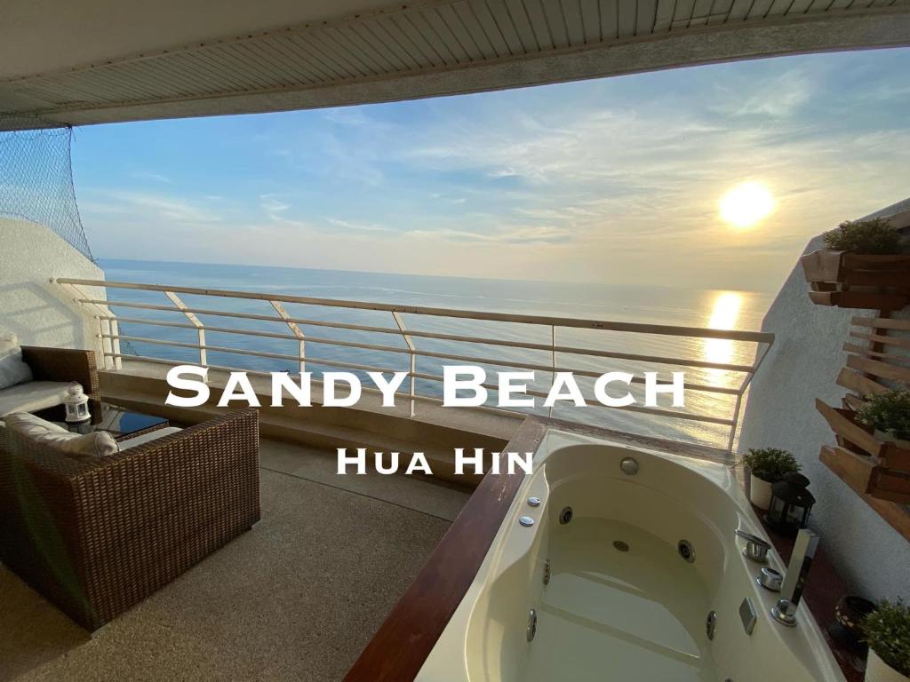 a bath tub on a balcony with a view of the ocean at Sandy Beach Condo 17D in Cha Am