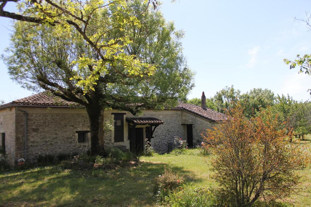 ValeillesにあるGîte l'Odonataの庭に木のある古い石造りの家