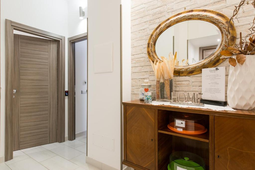 La salle de bains est pourvue d'un miroir et d'une commode en bois. dans l'établissement Casette Romane "Daje!", à Rome