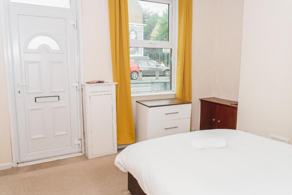 a bedroom with a white bed and a window at Hanley Park House in Stoke on Trent