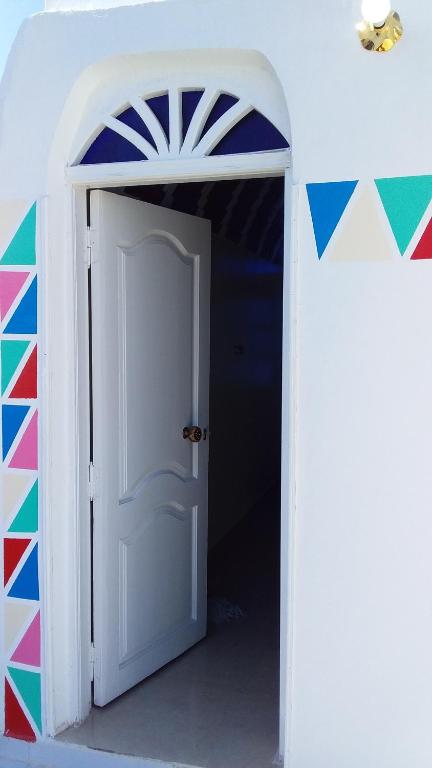an open white door with a flag painted on it at Roma House in Aswan