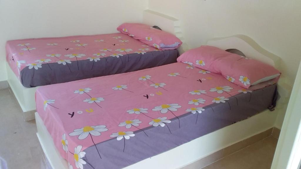 a bedroom with two beds with flowers on them at Roma House in Aswan