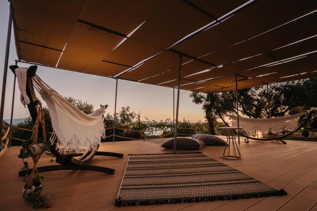 a patio with a hammock and a rug on a deck at AIORA villas in Ammouliani
