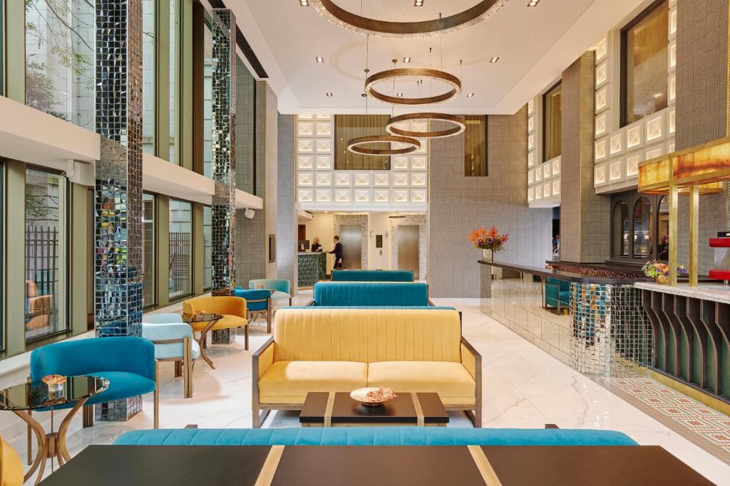 a lobby of a store with blue chairs and tables at The Grafton Hotel in Dublin