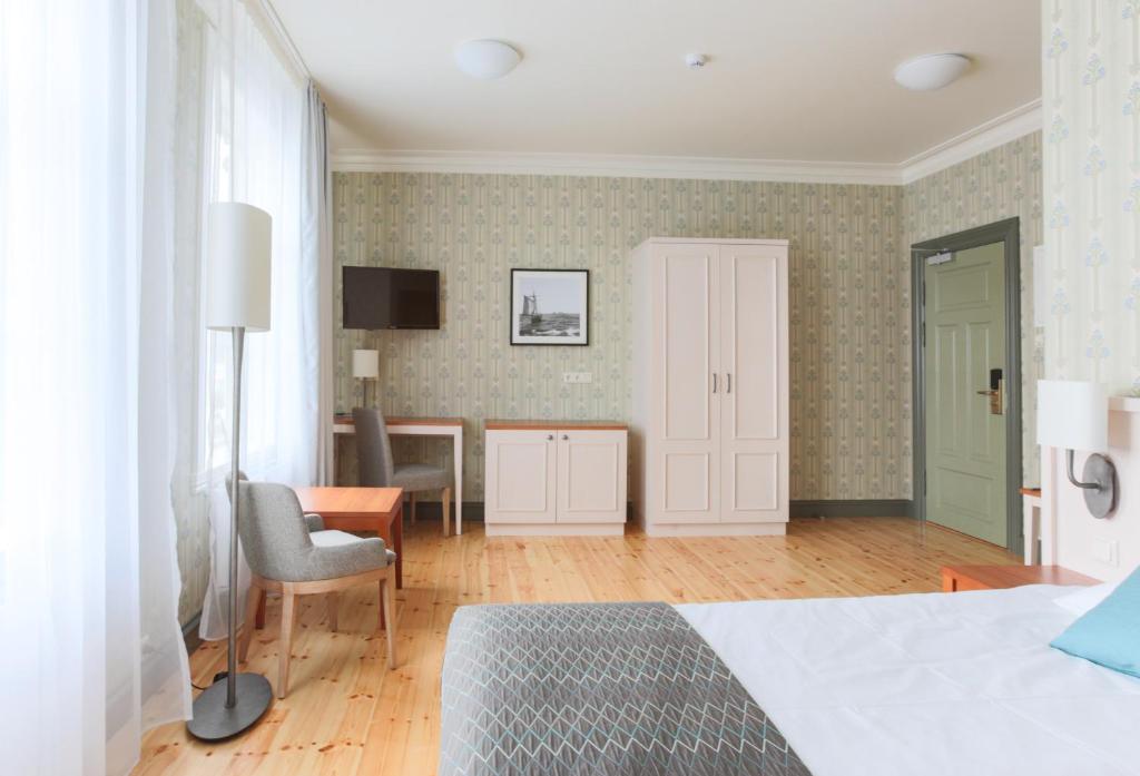 a bedroom with a bed and a desk and a chair at Fosshotel Eastfjords in Fáskrúðsfjörður