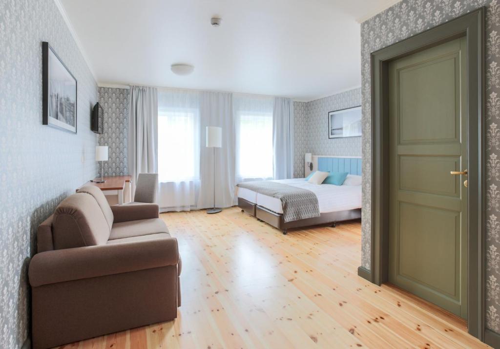 a hotel room with a bed and a couch and a door at Fosshotel Eastfjords in Fáskrúðsfjörður