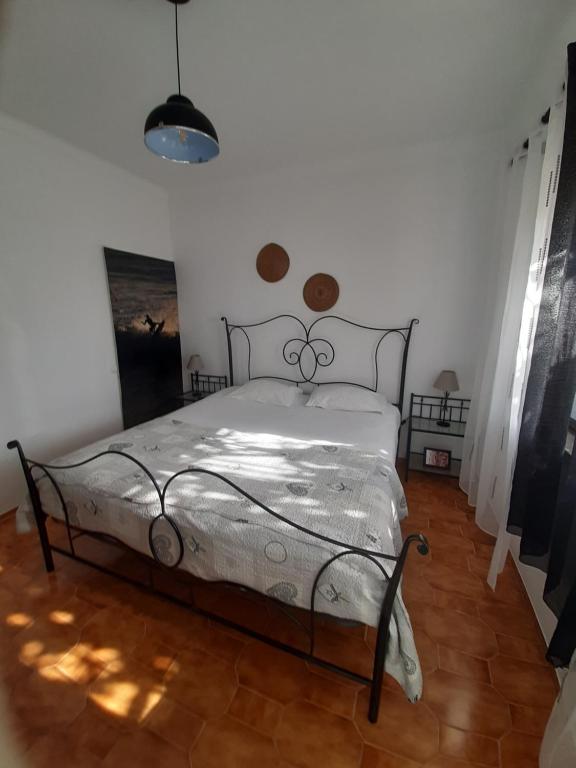 a bedroom with a bed in a white room at Casa Oceano in Praia da Arrifana