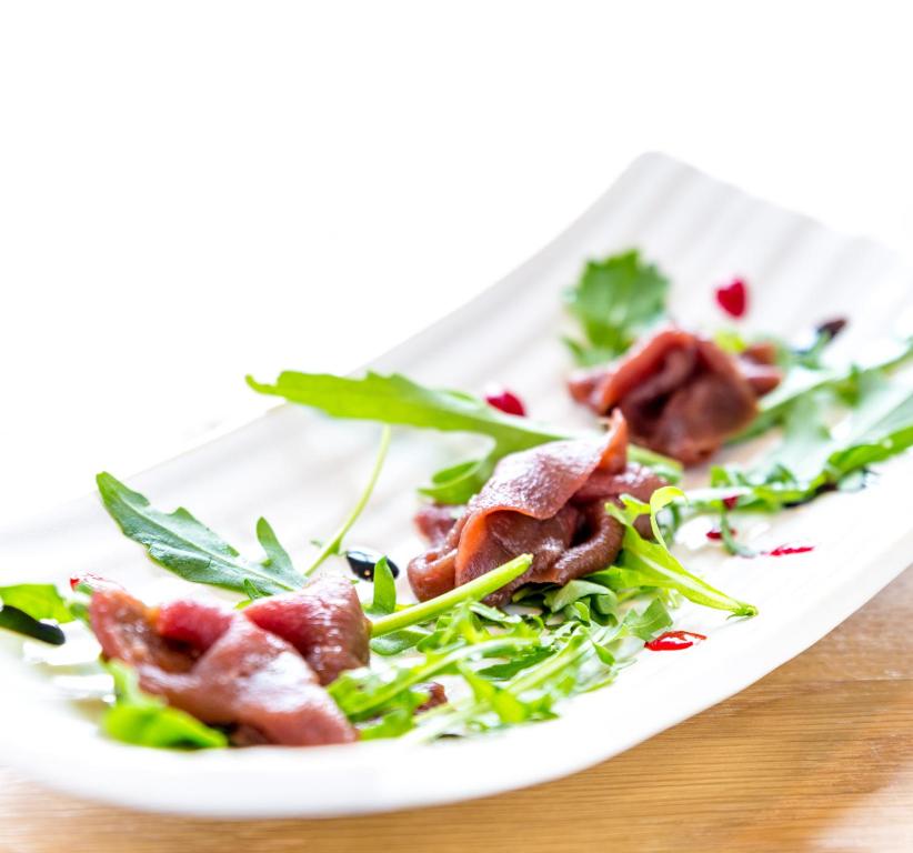 a plate of salad with bacon on a table at Fosshotel Eastfjords in Fáskrúðsfjörður