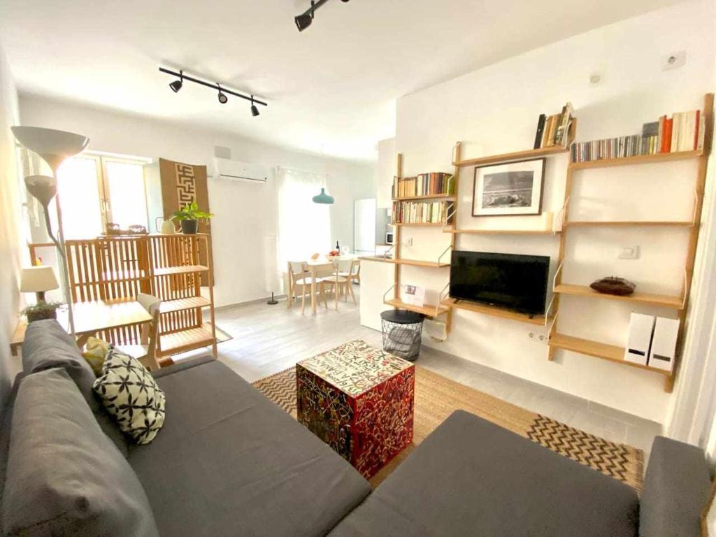 un soggiorno con divano, TV e tavolo di MonKeys Apartments Los Viajantes a Siviglia