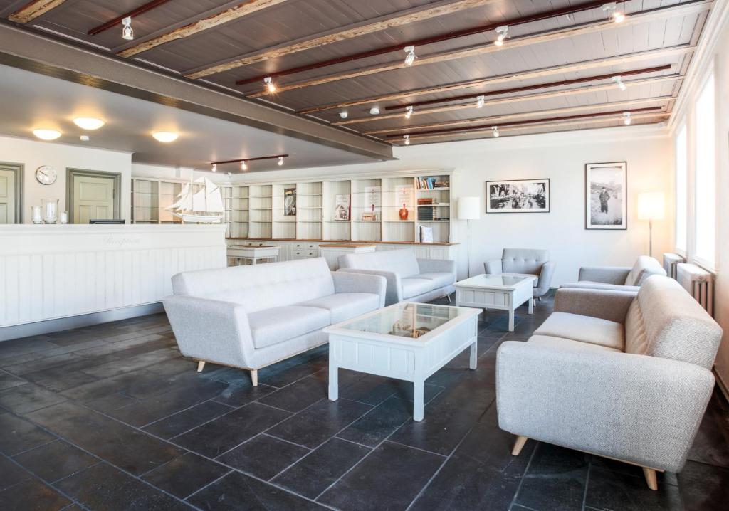 a large living room with couches and a table at Fosshotel Eastfjords in Fáskrúðsfjörður