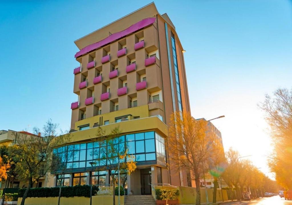 um edifício alto com acentos cor-de-rosa em Hotel Atlantic Vista Mare em Pesaro