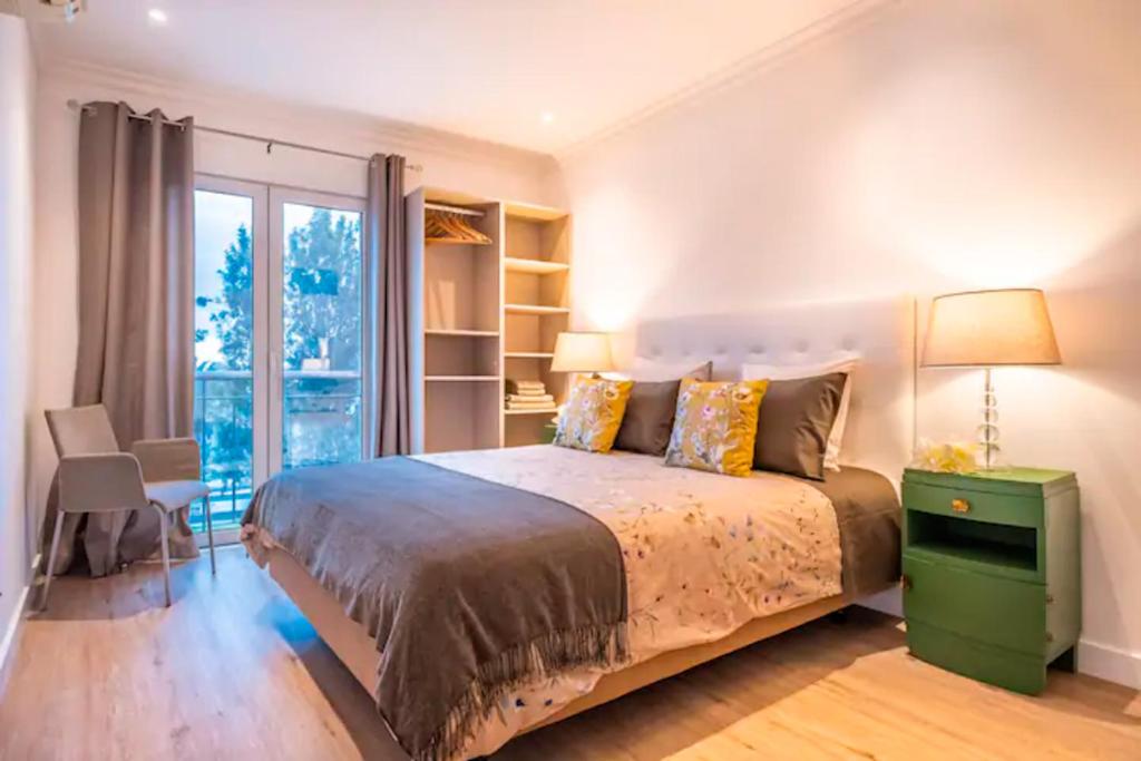 フンシャルにあるFunchal Center Apartment IIのベッドと大きな窓のある寝室