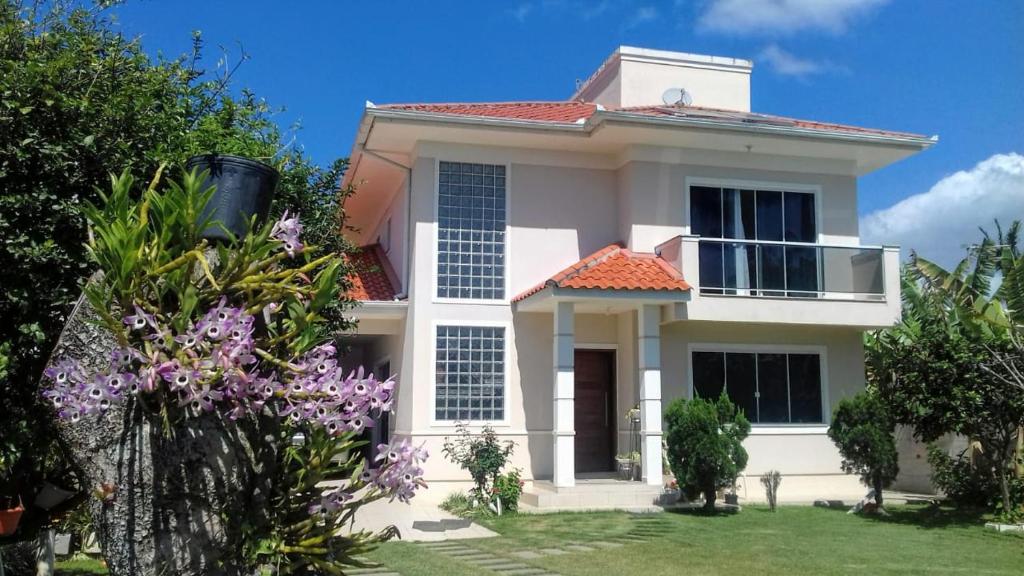 uma casa branca com um telhado vermelho em Linda Casa de Praia (Morada 3R's) Florianópolis/SC em Florianópolis