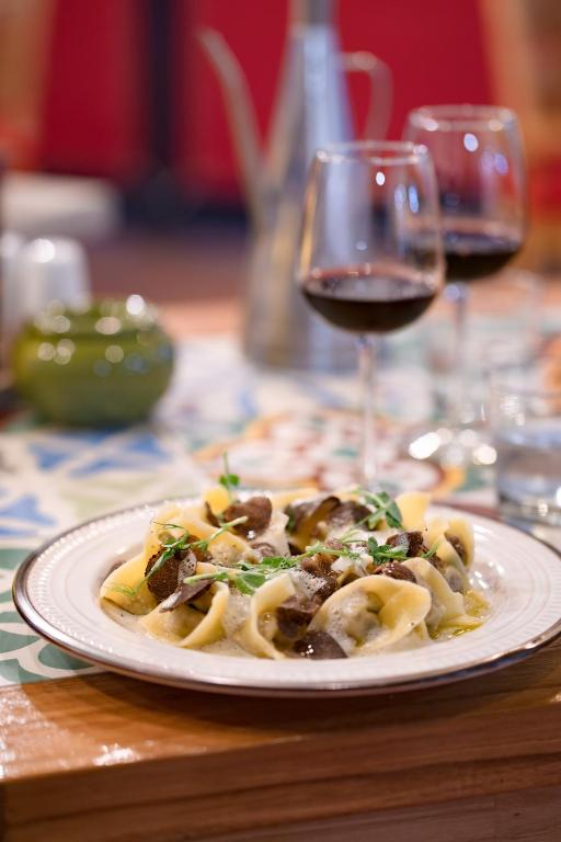 a plate of pasta on a table with a glass of wine at Blue Sail Hotel in Anse Marcel 