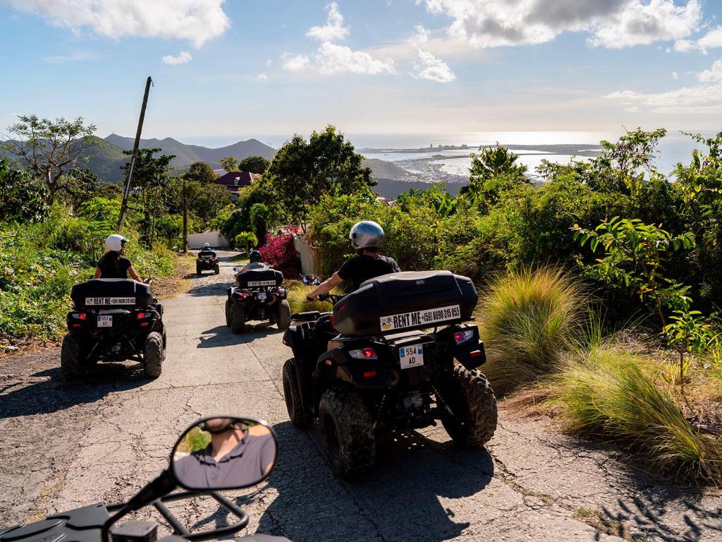 a group of people riding motorcycles down a road at Blue Sail Hotel in Anse Marcel 
