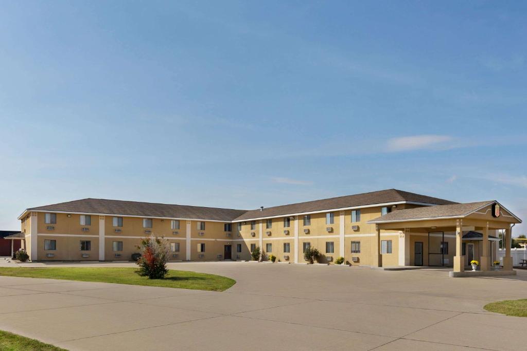 a large tan building with a parking lot at Super 8 by Wyndham Sikeston/Miner Area in Sikeston