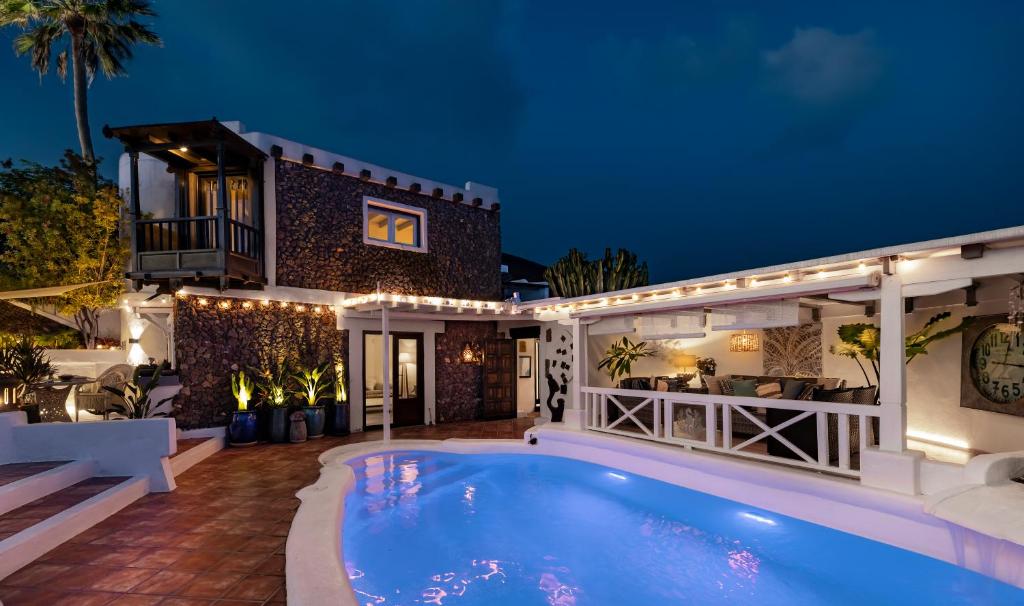 a villa with a swimming pool at night at Deluxe designer historic villa Via Lactea, Panoramic sea views, Own private heated pool and subtropical garden in La Asomada